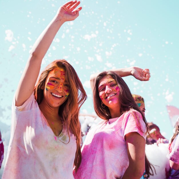 Mujeres jóvenes bailando y disfrutando del festival holi.