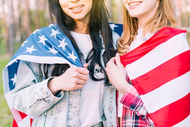 Foto gratuita mujeres jóvenes con bandera abrazando