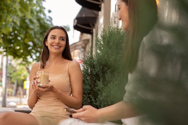 Foto gratuita mujeres jóvenes bebiendo café helado