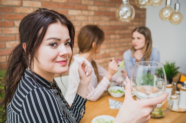 Mujeres jóvenes bebiendo vino y charlando