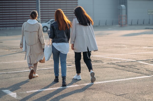 Mujeres jóvenes con bolsas de compras caminando en la calle.