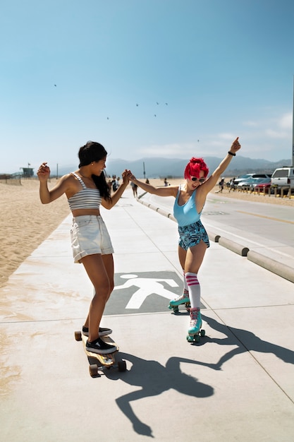 Foto gratuita mujeres jóvenes con cabello teñido cerca de la playa