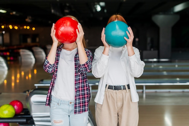 Mujeres jóvenes con coloridas bolas de boliche