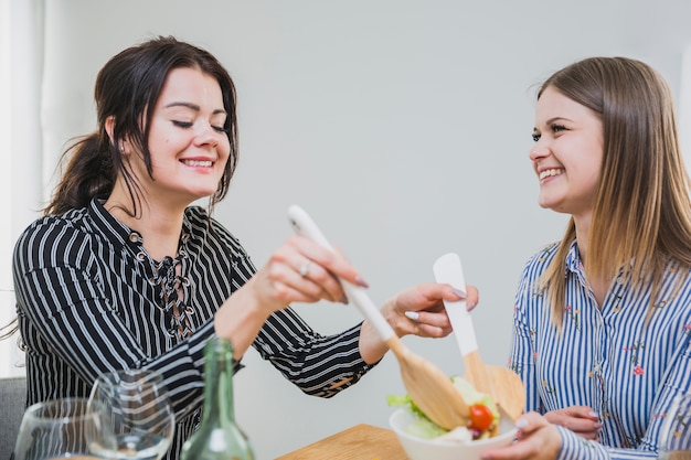 Mujeres jóvenes comiendo juntos