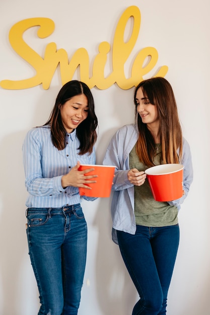 Mujeres jóvenes con cubos de palomitas de maíz