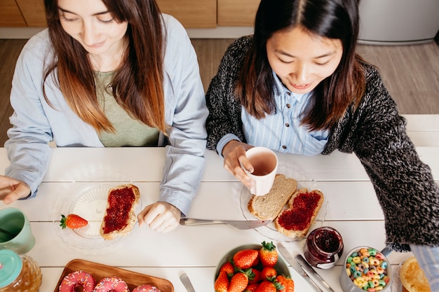 Foto gratuita mujeres jóvenes disfrutando de un desayuno dulce