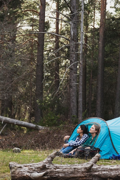 Mujeres jóvenes disfrutando de la naturaleza en la tienda de campaña