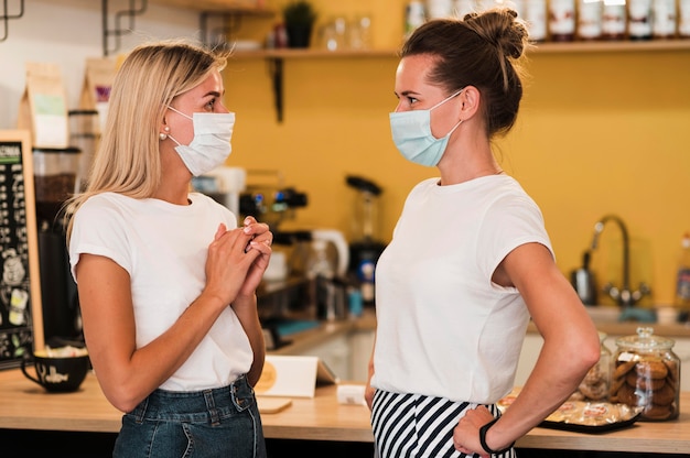 Mujeres jóvenes con estilo con máscaras faciales