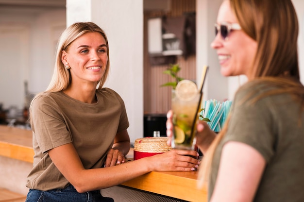 Mujeres jóvenes con estilo tomando cócteles juntos