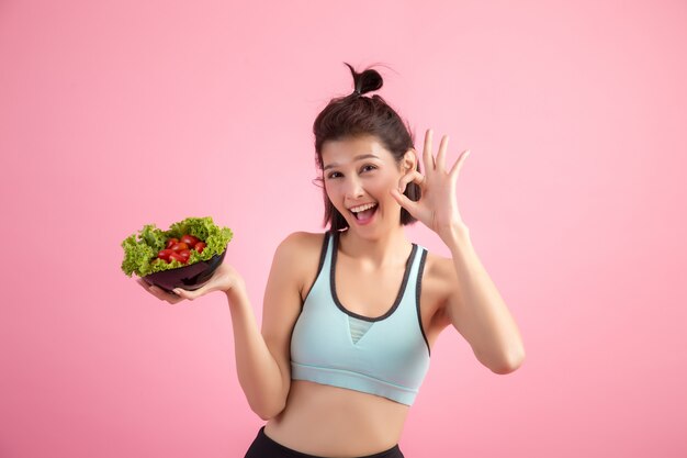 A las mujeres jóvenes les gusta comer verduras en una rosa.