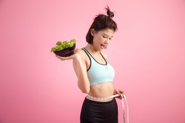 A las mujeres jóvenes les gusta comer verduras en una rosa.