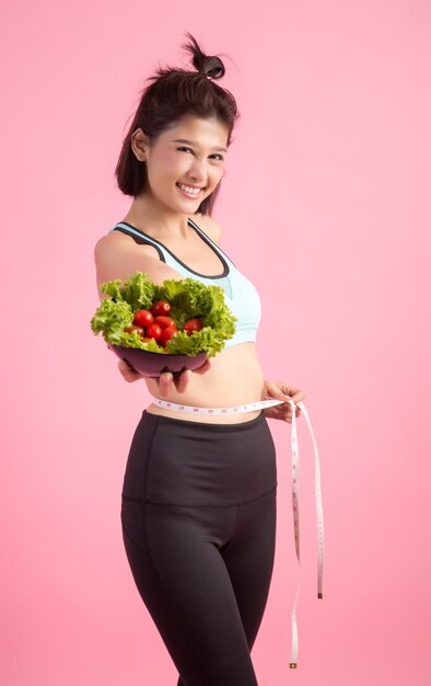 A las mujeres jóvenes les gusta comer verduras en una rosa.