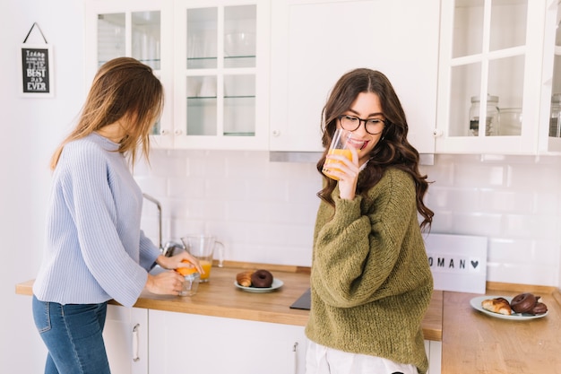 Foto gratuita mujeres jóvenes haciendo jugo de naranja