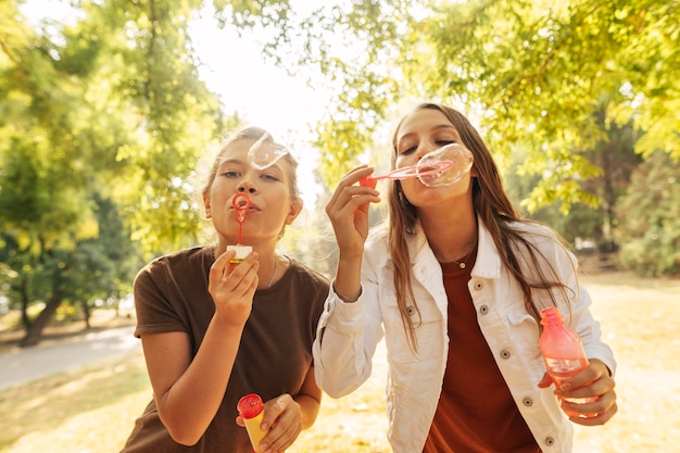 Mujeres jóvenes haciendo pompas de jabón