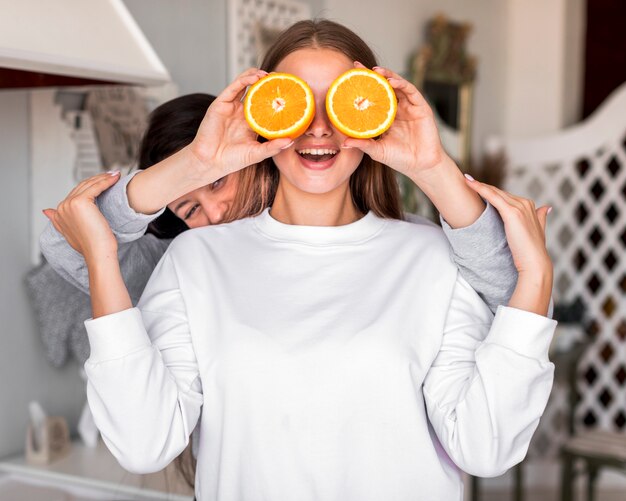 Mujeres jóvenes jugando con naranjas