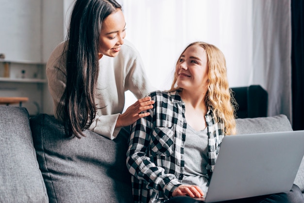 Mujeres jóvenes con laptop chateando