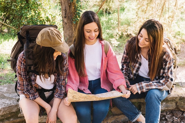 Mujeres jóvenes leyendo el mapa en el puente