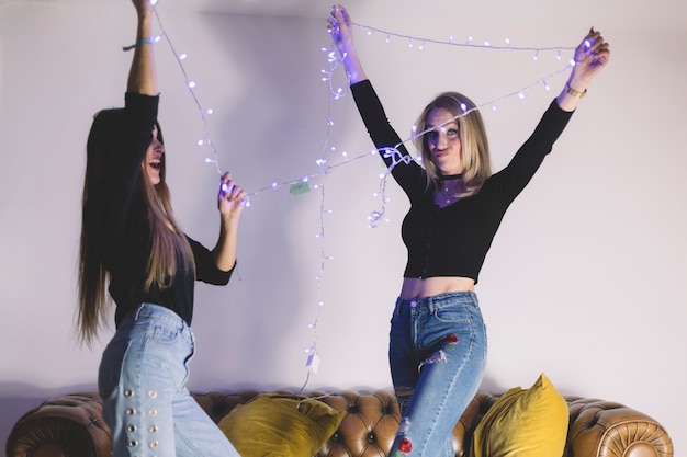 Foto gratuita mujeres jóvenes con luces de hadas