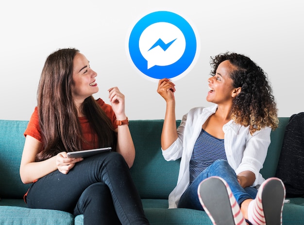 Foto gratuita mujeres jóvenes mostrando un ícono de facebook messenger