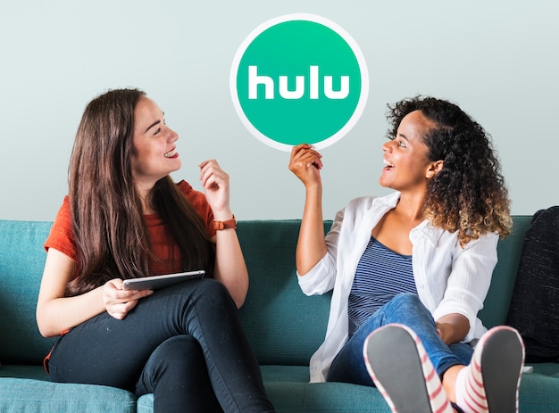 Foto gratuita mujeres jóvenes mostrando un icono de hulu