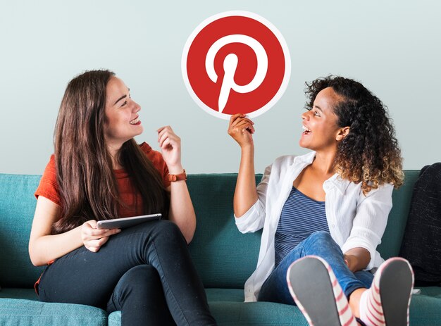 Mujeres jóvenes mostrando un ícono de Pinterest