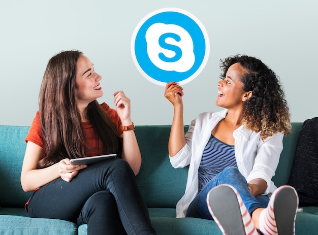 Foto gratuita mujeres jóvenes mostrando un icono de skype
