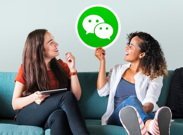 Mujeres jóvenes mostrando un ícono de WeChat