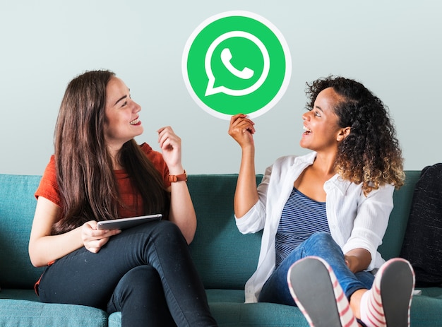 Foto gratuita mujeres jóvenes mostrando un icono de whatsapp messenger