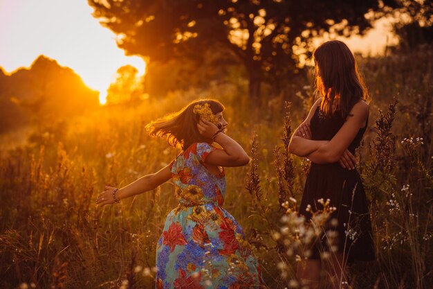 Las mujeres jóvenes posan en el campo de la tarde