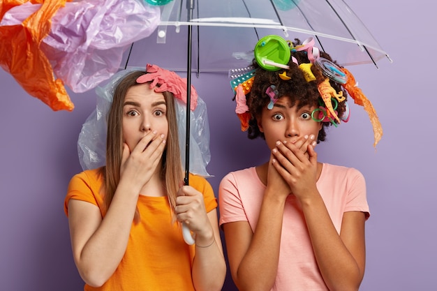 Mujeres jóvenes posando con residuos plásticos