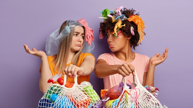 Mujeres jóvenes posando con residuos plásticos