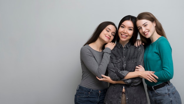 Foto gratuita mujeres jóvenes positivas posando juntas