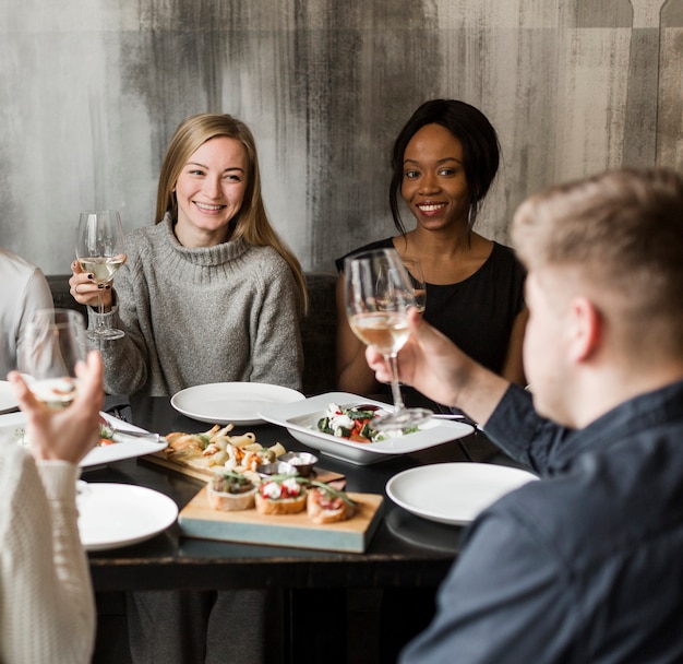 Mujeres jóvenes positivas sonriendo en la cena