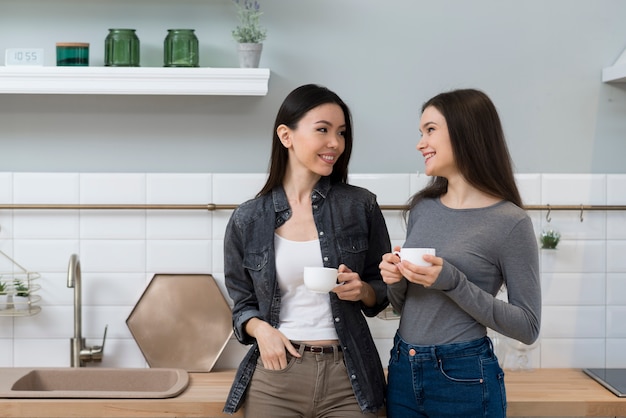 Mujeres jóvenes positivas tomando café juntos