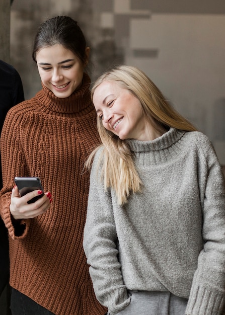 Mujeres jóvenes positivas viendo un video en un teléfono