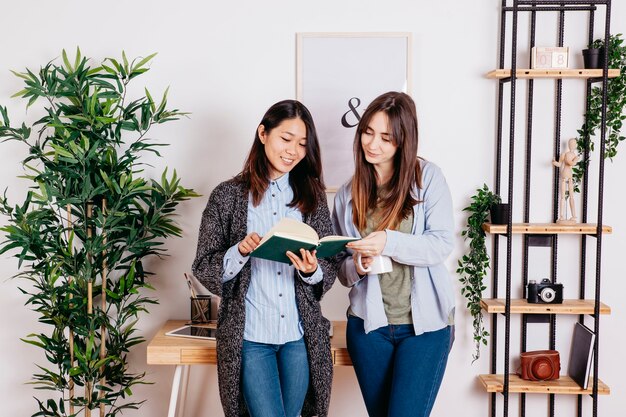 Mujeres jóvenes que comparten el libro juntos