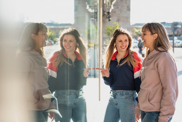 Las mujeres jóvenes reflejando imaginar en la ventana