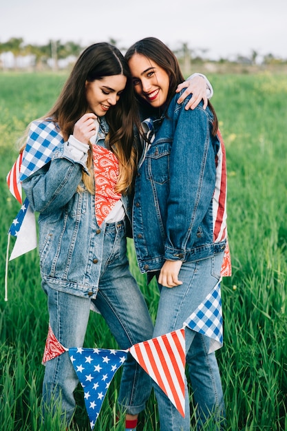 Mujeres jóvenes riendo afuera y abrazándose