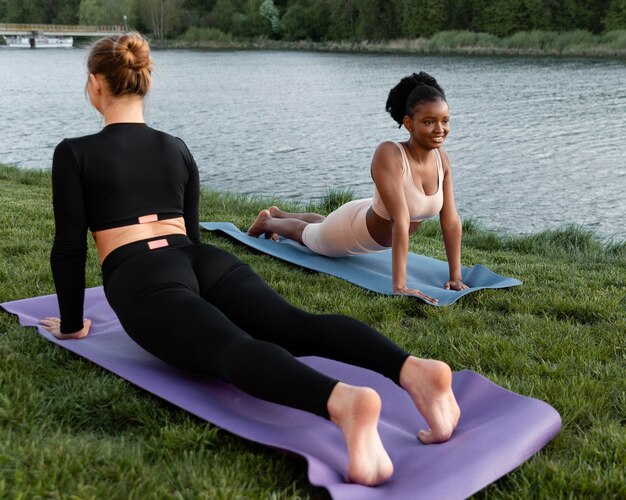 Mujeres jóvenes en ropa deportiva trabajando al aire libre