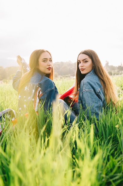 Mujeres jóvenes sentados en la luz del sol