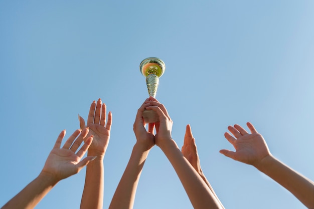 Mujeres jóvenes sosteniendo una copa de deportes