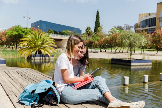 Mujeres jóvenes con tableta en el parque