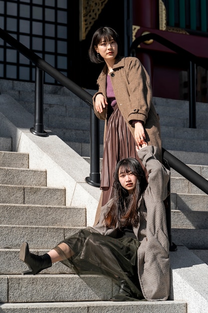 Mujeres jóvenes de tiro completo posando en las escaleras