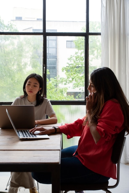 Mujeres jóvenes de tiro medio con dispositivos.