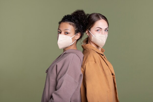 Mujeres jóvenes de tiro medio con mascarillas.