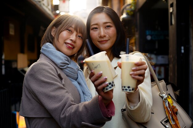 Mujeres jóvenes de tiro medio con té de burbujas