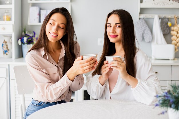 Mujeres jóvenes tomando café en casa