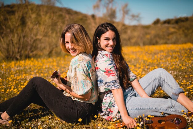 Mujeres jóvenes con ukeleles en el campo