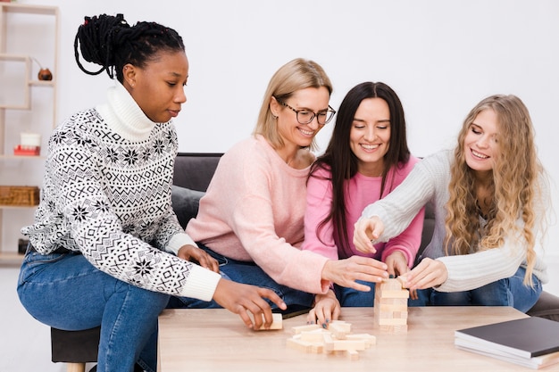 Mujeres jugando juntas un juego de torres de madera