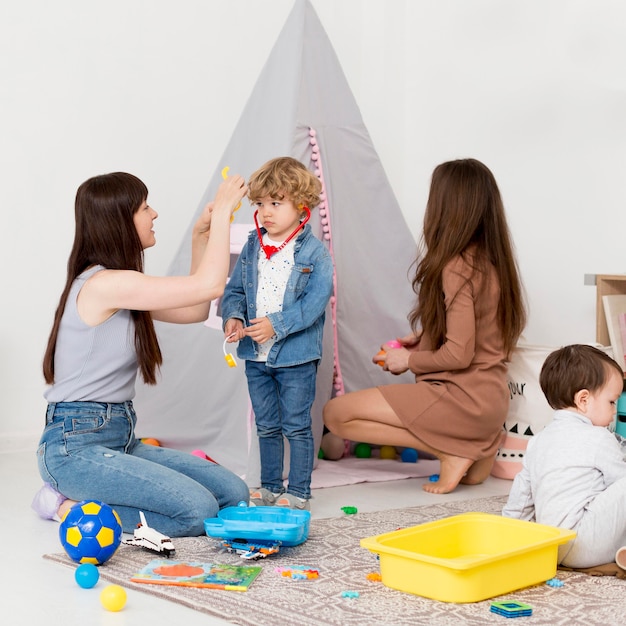 Mujeres jugando con niños en casa